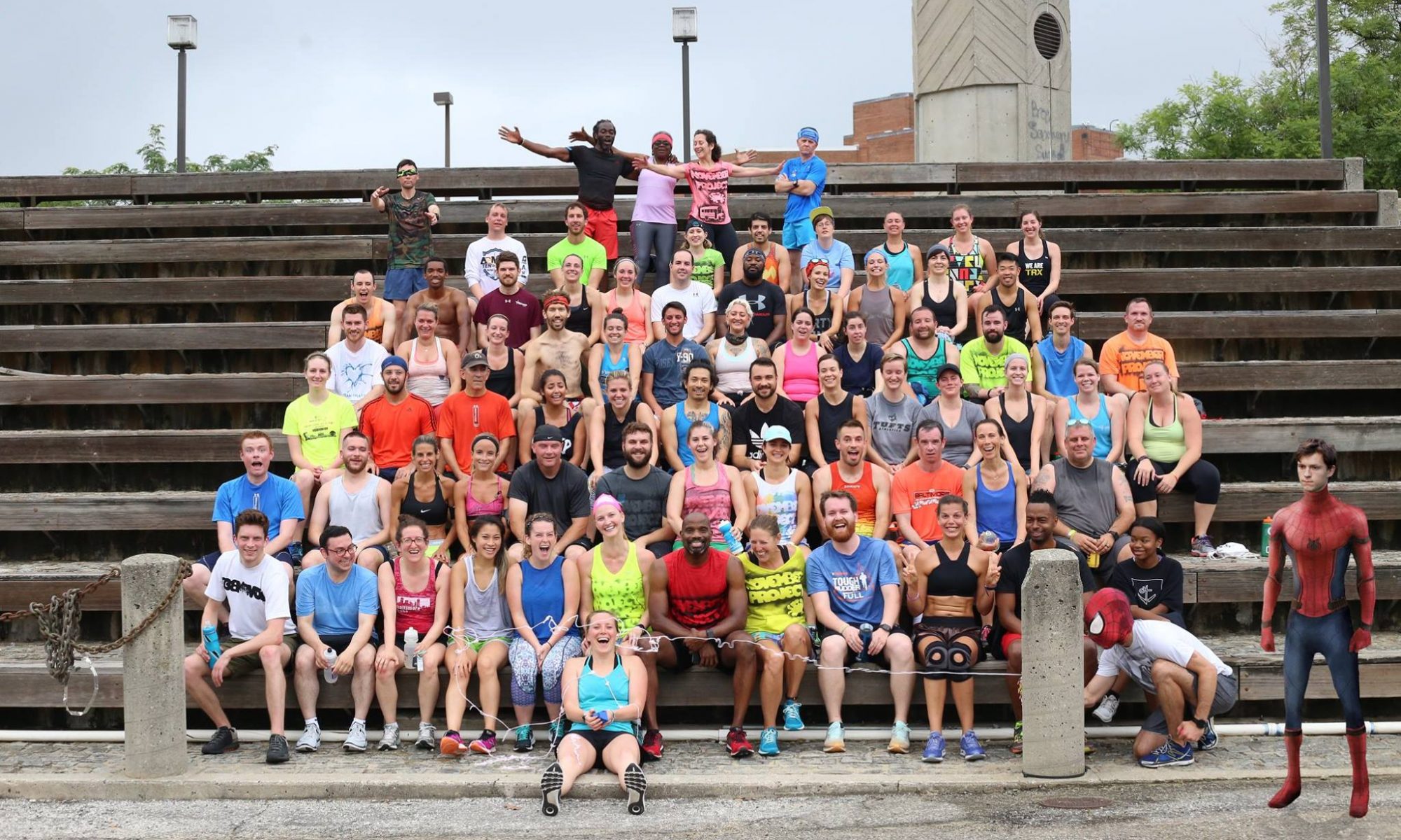 large group of people sitting on bleachers after a workout.