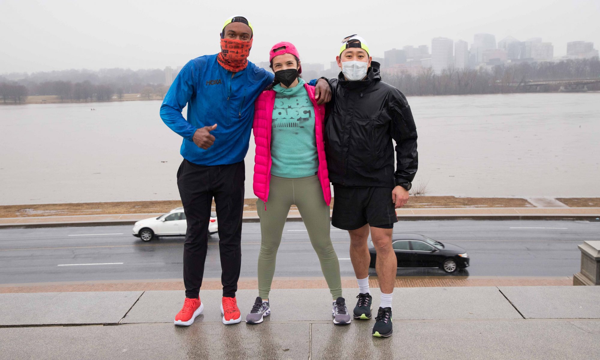 An image of Chris Jolly, Katherine Foley, and Young Joo standing in front of the stairs behind the Lincoln on a grey day. Everyone is wearing masks.