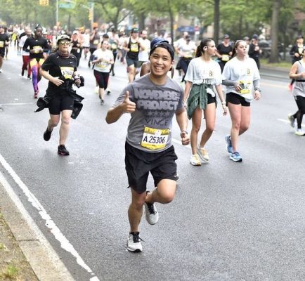 Vince Fuentes running in the race, smiling and giving thumbs up