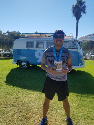 Vince Fuentes posing in front of NPSUMMIT 9 branded VW vintage bus