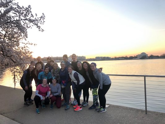 A crowd of people posing in front of the Anacostia River