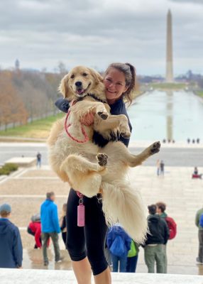 Liz holding up Maize in front of the Washington Monument